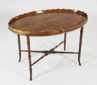 A mahogany oval occasional table, the 19th century tray top with wavy gallery on a later faux