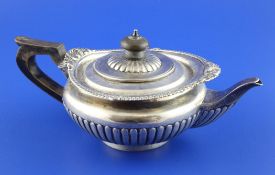 A Victorian demi fluted silver bachelor`s teapot, of squat circular form, with gadrooned and shell