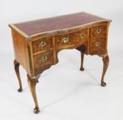 An 18th century style serpentine walnut writing table, with red leather skiver over five drawers,