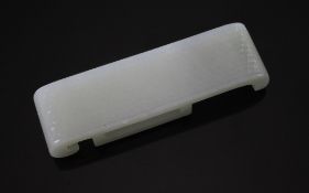 A Chinese pale celadon jade sword slide, the top carved with a grid of studs, 9.5cm.