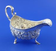 A George III Irish silver sauceboat, with acanthus leaf capped scroll handle and embossed with