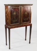 An Edwardian mahogany and polychrome painted two door cabinet on stand, with pigeon hole interior,