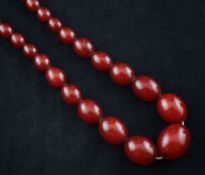 A single strand graduated simulated red amber bead necklace, 35in.