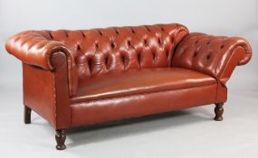A brown leather buttoned drop end Chesterfield settee, on turned oak supports
