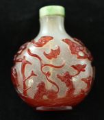 A Chinese red overlay glass snuff bottle, 1750-1880, carved in high relief with a sage and
