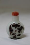 A Chinese inky purple and opaque white overlay glass snuff bottle, 1850-1940, with two bats each