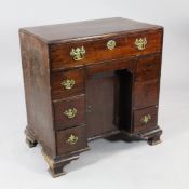 A George III mahogany kneehole desk, fitted seven drawers around a central recessed cupboard, on