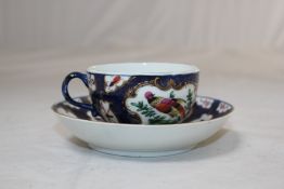 A Worcester blue scale ground coffee cup and saucer, c.1770, decorated with painted exotic birds,