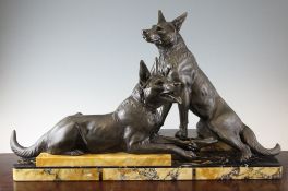 L. Carvin. An Art Deco bronzed spelter group of two hounds, seated upon a stepped marble plinth,