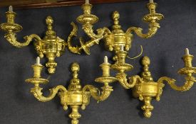 A set of four 20th century gilt metal wall lights, each with twin scrolling branches and circular