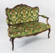 A late Victorian carved walnut open arm settee, with acanthus C scroll decoration, green patterned