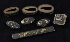 Seven Japanese shakudo work sword fittings and a brooch pin, 19th century, the sword fittings