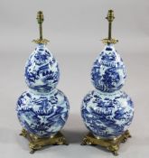 A pair of Chinese blue and white double gourd shaped ormolu mounted lamp bases, each painted with