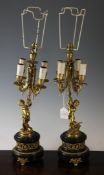 A pair of late 19th / early 20th century ormolu figural candelabra, modelled as cherubs holding