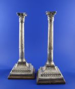 A pair of George III silver corinthian column candlesticks, converted to table lamps, now on wooden