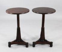 A pair of circular mahogany occasional tables, with stiff leaf carved pedestal and triform platform