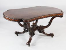 A Victorian burr walnut centre table, the shaped top with scroll carved border, on four scrolling