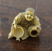 A Japanese ivory netsuke of a long haired seated man, early 20th century, holding a dish and a