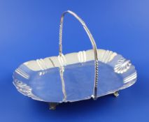 A Victorian silver cake basket, of oval form, with fluted and shell decorated border, on four