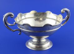 An Edwardian silver two handled rose bowl, of circular form, with flying scroll handles, on