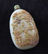 A Chinese celadon and russet jade and cameo `pebble` snuff bottle, 19th century, carved in relief