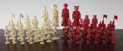 A Chinese carved ivory chess set, each with concentric ball bases, complete with thirty two red