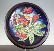 A Moorcroft Simeon pottery charger, c.2000, impressed and inscribed marks, 14.5in., wood frame