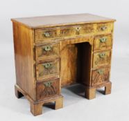 An 18th century and later walnut kneehole desk, fitted an arrangement of seven drawers around a