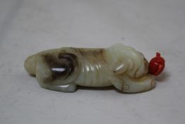 A Chinese white and black jade `lion-dog` snuff bottle, 18th / 19th century, modelled as a