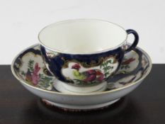 A Worcester blue scale ground coffee cup and saucer, c.1770, decorated with painted exotic birds