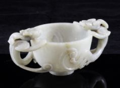 A Chinese celadon green jade twin handled cup, Ming dynasty, carved in relief and open work with a