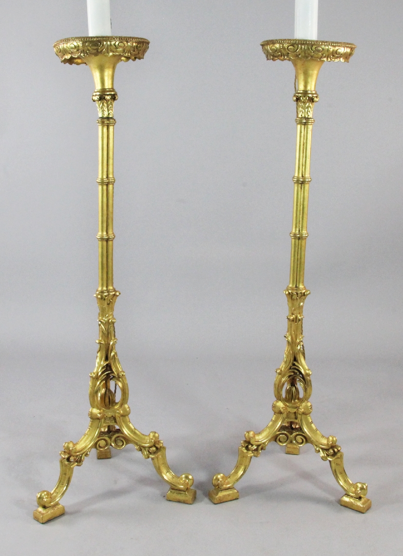 A pair of carved giltwood torcheres, now modelled as lamps, the circular tops on cluster columns
