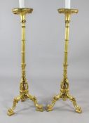 A pair of carved giltwood torcheres, now modelled as lamps, the circular tops on cluster columns
