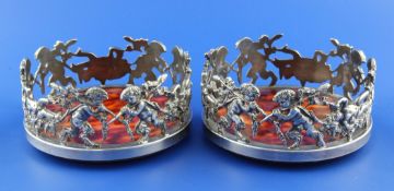 A pair of modern silver plated wine coasters, the pierced galleries decorated with fawns and putti,