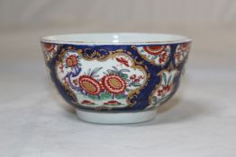 A Worcester blue scale ground bowl, c.1770 decorated in the Kakiemon style with painted flowers,
