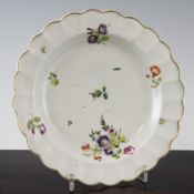 A Worcester polychrome dessert plate, c.1770, with a gilded scalloped rim and decorated with