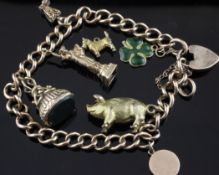 A 9ct gold curb link charm bracelet, hung with two charms and five loose charms, gross weight 31.1