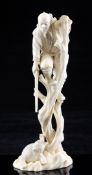 A Japanese ivory okimono of a hunter climbing out of the reach of a bear, Taisho period, the