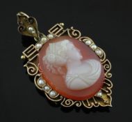 A Victorian gold, seed pearl and hardstone cameo pendant locket, with scroll border and carved with