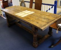 A 17th century style oak refectory table, the rectangular top on gun barrel supports united by H