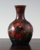 A Moorcroft flambe Clematis bottle vase, c.1955, impressed marks and paper label Potters to the