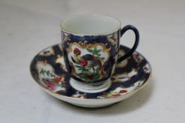 A Worcester blue scale ground coffee cup and saucer, c.1770, decorated with painted exotic birds,