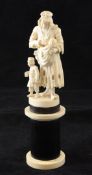 A 19th century Dieppe ivory carving of a beggar woman suckling a child, on a circular ebony and