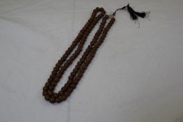 A Buddhist necklace composed of one hundred and eight treen beads, interspersed by agate beads,