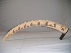 A South East Asian ivory tusk carving, depicting a row of elephants, 24in.