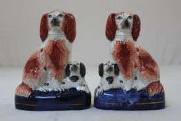 Three pairs of Staffordshire pottery figures of spaniels, mid 19th century, the first pair with