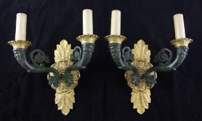 A pair of Empire style gilt and patinated bronze two branch wall lights, the scrolling branches with