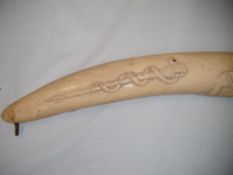 An African ivory tusk carving, depicting figures, swords and instruments, 27in.