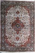 A Tabriz style part silk carpet, with field of scrolling foliage and central medallion on an ivory