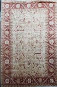An Indo Persian carpet, with field of geometric foliate motifs, on an ivory and red ground, with